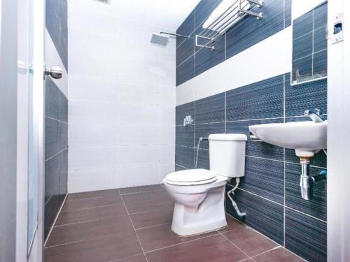 a bathroom with a toilet and a sink at Hotel Aromas Kulai in Johor Bahru