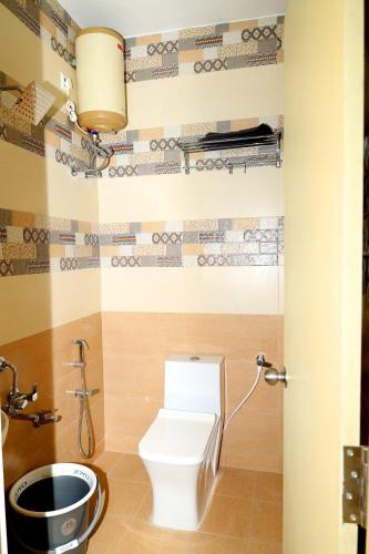 a bathroom with a white toilet in a room at Sendhuran Residence in Tiruchchirāppalli