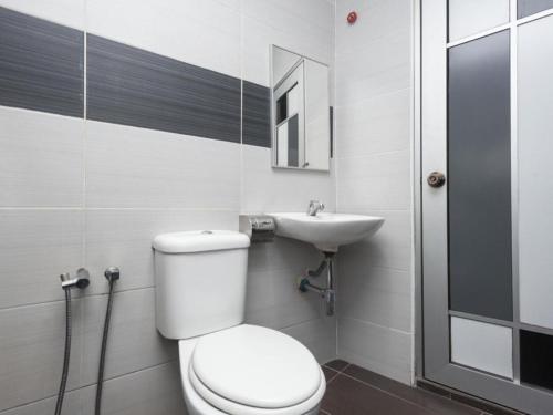 a bathroom with a toilet and a sink at Hotel Aromas Kulai in Johor Bahru