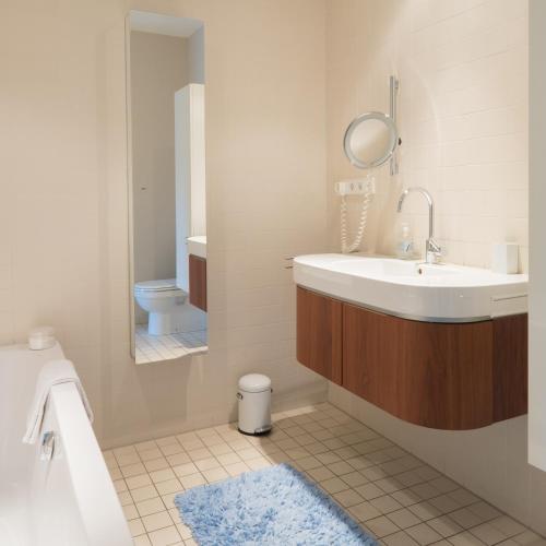 a bathroom with a sink and a toilet and a mirror at Villa Yburg in Amsterdam