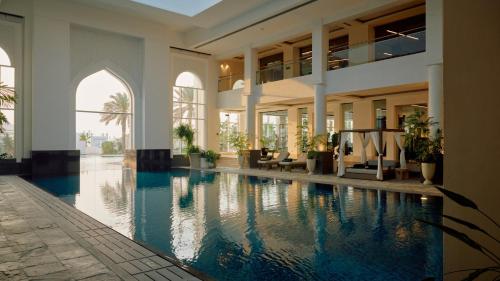 a building with a swimming pool in the middle at Raffles Al Areen Palace Bahrain in Manama
