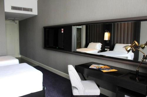 a hotel room with a desk and a mirror at Hatten Place Melaka in Melaka
