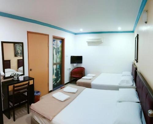 a hotel room with two beds and a desk and a bedroom at Twin Star Hotel in Tanjung Malim