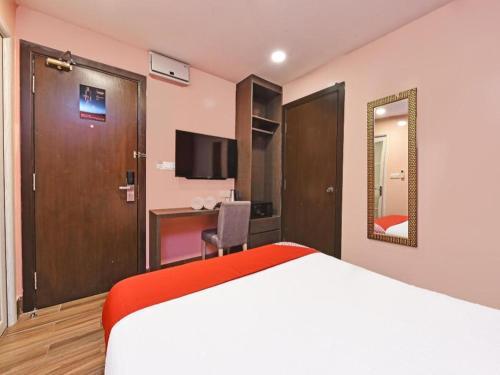 a hotel room with a bed and a desk at Capital O 90574 Hotel Glo in Kuala Lumpur