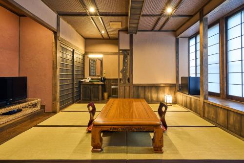 a large room with a wooden table and chairs at Shinwaen in Aso