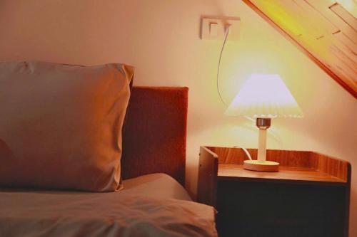 a lamp on a table next to a bed at Phố Thường Garden in Da Lat