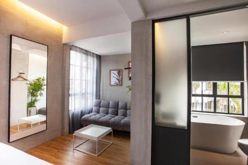 a bathroom with a couch and a tub in a room at Atelier Hotel Johor Bahru in Johor Bahru