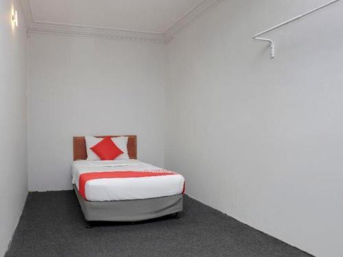 a small bedroom with a bed in a white room at OYO 90120 MI Hotel Dungun in Dungun