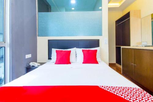 a bedroom with a large bed with red pillows at OYO 90429 Hotel Narasindo in Kuala Lumpur