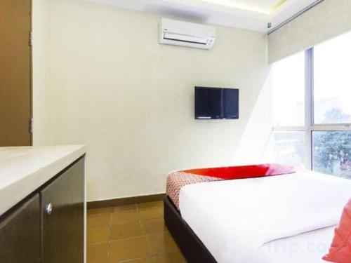 a bedroom with a bed and a tv on the wall at OYO 90429 Hotel Narasindo in Kuala Lumpur