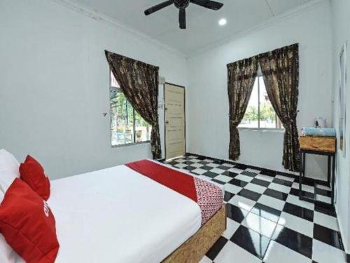 a bedroom with a bed and a checkered floor at OYO 90507 Chalet Sumayyah in Melaka