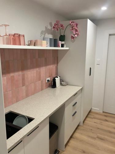 a kitchen with a counter top with flowers on a shelf at Seatoun Shores in Wellington