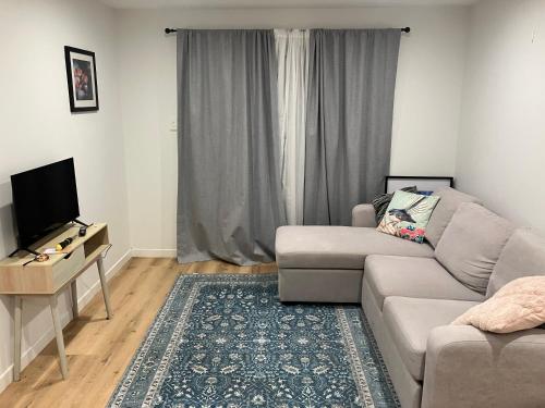 a living room with a couch and a flat screen tv at Seatoun Shores in Wellington