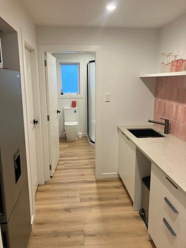 a kitchen with a hallway with a toilet in it at Seatoun Shores in Wellington