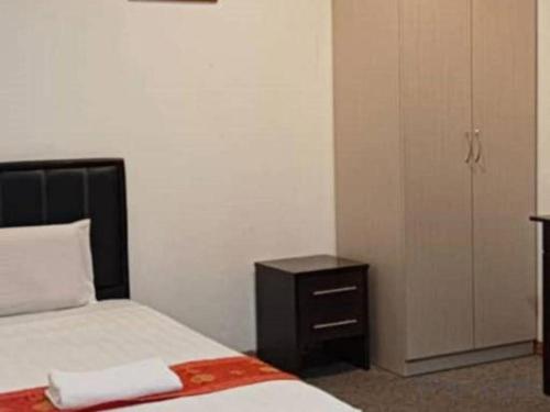 a bedroom with a bed and a dresser and a closet at OYO 90785 Pandan Hotel in Kota Kinabalu