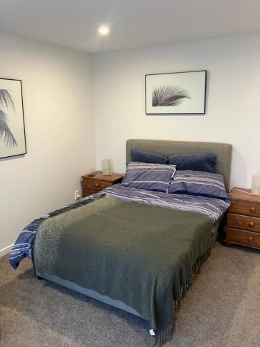 a bedroom with a bed and two pictures on the wall at Seatoun Shores in Wellington