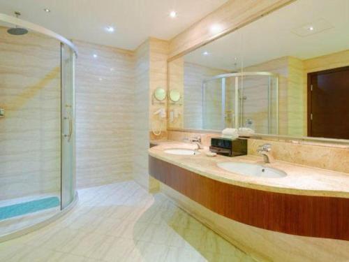 a bathroom with two sinks and a shower at Haikou Conifer Garden Hotel in Haikou
