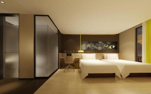 ein Schlafzimmer mit einem großen Bett und einem Stuhl in der Unterkunft IU Hotels·Xinyu City Government Xianlai Park in Xinyu