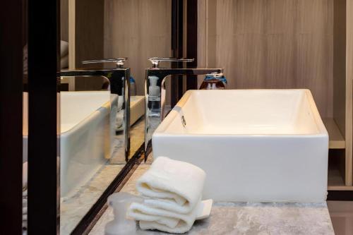 a bathroom with a white sink and a mirror at Echarm Hotel Guizhou Xingyi Jushan Avenue in Xiawutun