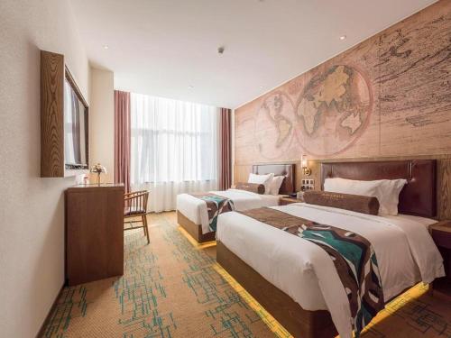 une chambre d'hôtel avec deux lits et un tableau au mur dans l'établissement James Joyce Coffetel Beijing Pinggu Hospital Century Square, à Yuegezhuang