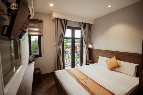 a bedroom with a large bed and a balcony at Nét Việt Hotel Vincom Sóc Trăng in Soc Trang