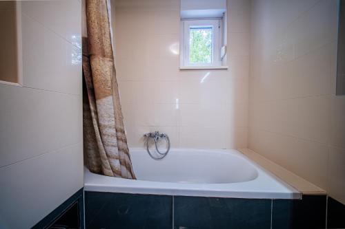 a bath tub in a bathroom with a window at Flex SelfCheckIns 169 - Zagreb - Loggia - Parking - 2 Bedroom in Zagreb