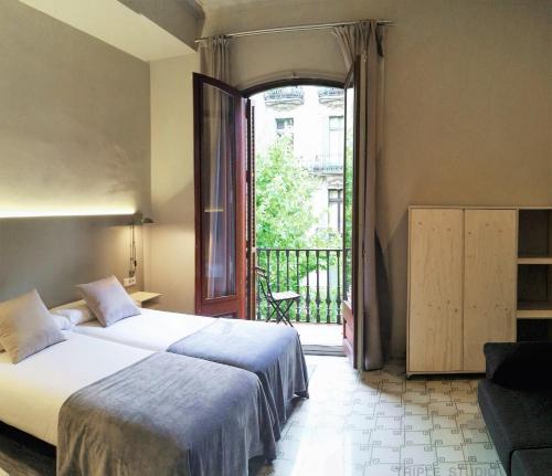 バルセロナにあるCasa Abamitaのベッドルーム1室(ベッド1台付)、バルコニーへのドアが備わります。