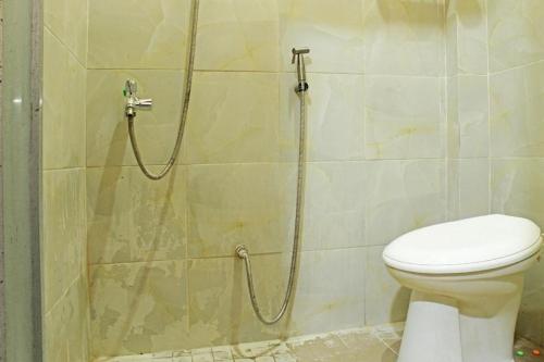 a bathroom with a shower with a toilet at Hotel O Amor Kost in Kupang