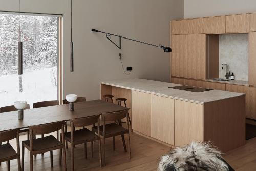 a kitchen and dining room with a table and a dog at Stay North - The House of Northern Lights in Äkäslompolo