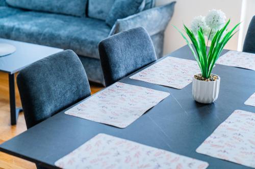 a black table with two chairs and a plant on it at Flex SelfCheckIns 169 - Zagreb - Loggia - Parking - 2 Bedroom in Zagreb