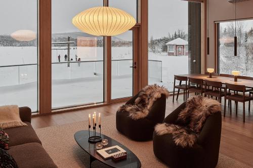 a living room with couches and a table with a view at Stay North - The House of Northern Lights in Äkäslompolo