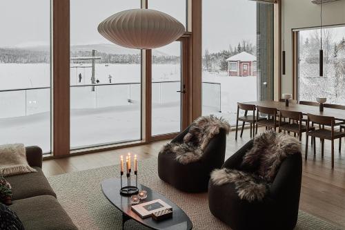 a living room with couches and a table with candles at Stay North - The House of Northern Lights in Äkäslompolo