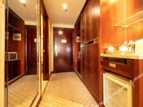 a bathroom with a hallway with a sink and a mirror at Kunshan Yuxing Hotel in Kunshan