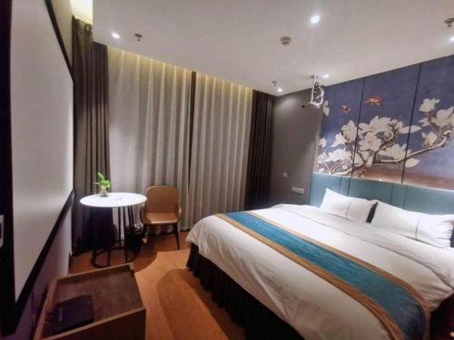 a hotel room with a large bed and a table at Magnotel Shenyang Consulate Qingnian Street in Shenyang