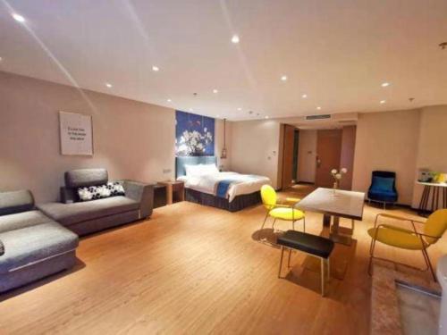 a hotel room with a bed and a couch at Magnotel Shenyang Consulate Qingnian Street in Shenyang
