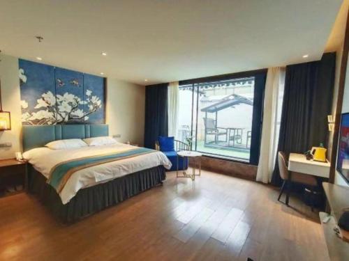 a bedroom with a bed and a desk and a window at Magnotel Shenyang Consulate Qingnian Street in Shenyang
