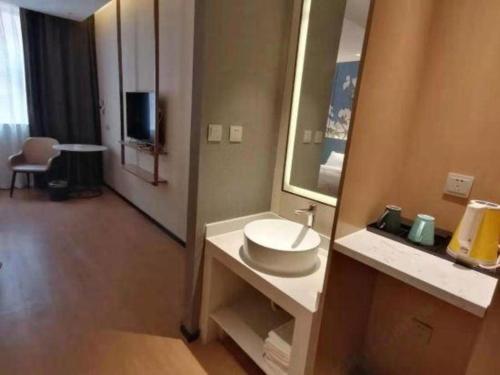 a bathroom with a sink and a mirror at Magnotel Shenyang Consulate Qingnian Street in Shenyang