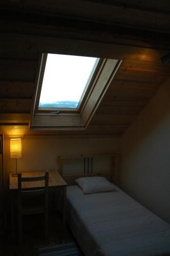 a bedroom with a window and a bed and a desk at Przystanek Rospuda in Sucha Wieś