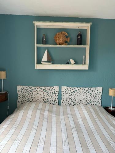 une chambre avec un lit avec un mur bleu dans l'établissement Chez Sophie et Vincent, à Cogolin