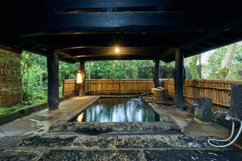 a pool of water under a pavilion at Shinwaen in Aso