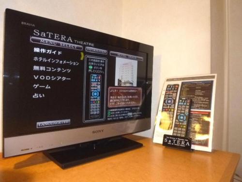 a computer monitor sitting on top of a wooden table at Smile Hotel Nishiakashi in Kobe