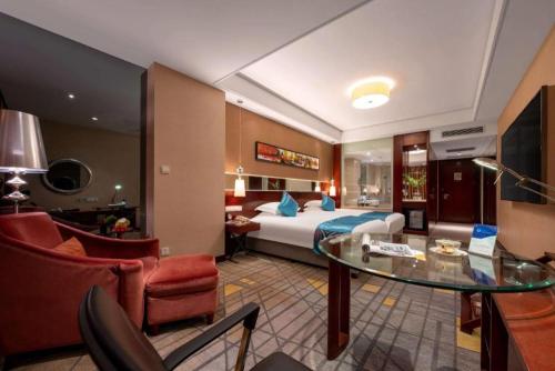 a hotel room with a bed and a glass table at Ramada by Wyndham Zibo in Zibo