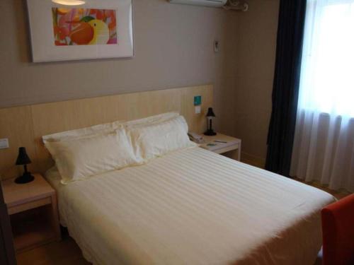 a bedroom with a white bed and a window at Jinjiang Inn Luoyang Wangcheng Park Metro Station in Luoyang