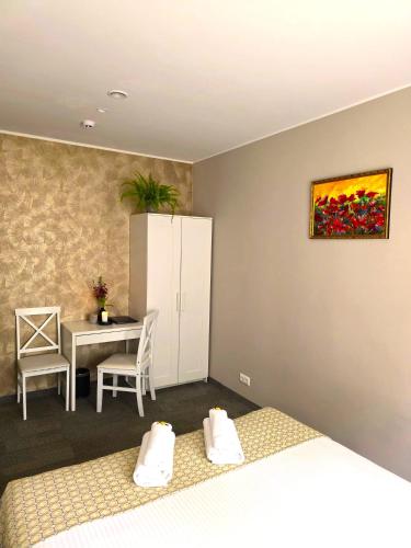 a bedroom with two beds and a table and a painting on the wall at Usmas muiža in Usma