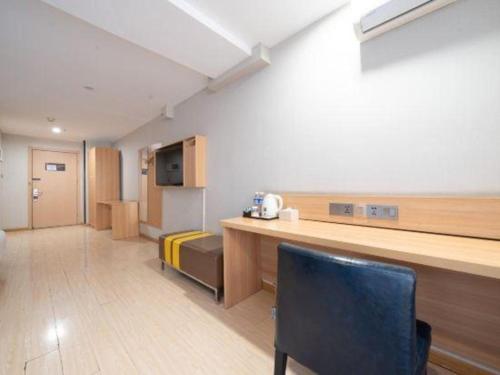 a room with a kitchen with a counter and a chair at 7 Days Premium Xi'an Dayan Tower Xiaozhai Metro Station in Xi'an