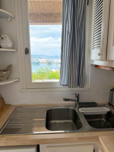 une cuisine avec un évier et une fenêtre dans l'établissement Chez Sophie et Vincent, à Cogolin