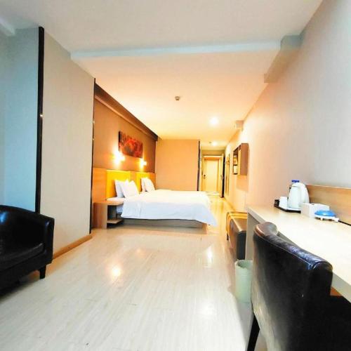 a hotel room with a bed and a chair at 7 Days Premium Xi'an Dayan Tower Xiaozhai Metro Station in Xi'an