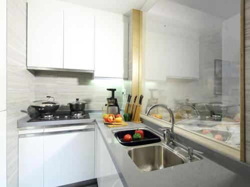a kitchen with a sink and a counter top at Huafa Executive Apartment Hotel Zhuhai in Zhuhai