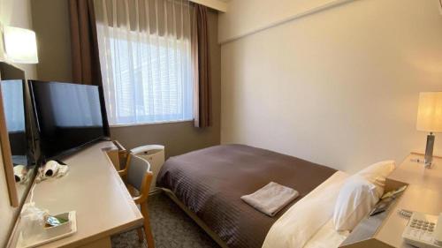 a hotel room with a bed and a desk at Hotel Castle Plaza in Kobe