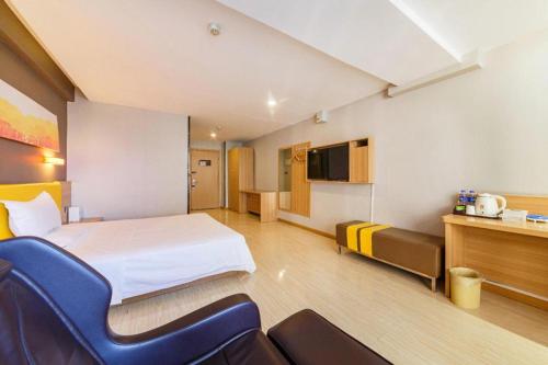 a hotel room with a bed and chairs in it at 7 Days Premium Xi'an Dayan Tower Xiaozhai Metro Station in Xi'an